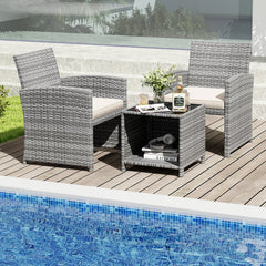 3 Piece Patio Rattan Bistro Set, 2 Grey Wicker Chairs Rated 400 lb with Beige Seat Cushions and an 18 in Glass Top Table with Shelf